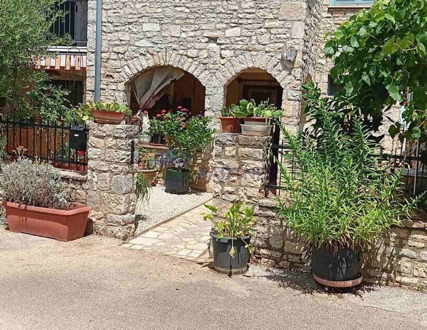 Steinhaus in der Mitte einer Reihe mit freiem Blick auf die grünen Felder